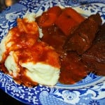 A plate of barbecue braised short ribs with mashed potatoes and carrots.