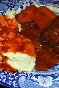 A plate of barbecue braised short ribs with mashed potatoes and carrots.