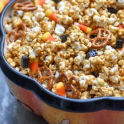 A side view of a Halloween themed bowl filled with caramel popcorn.