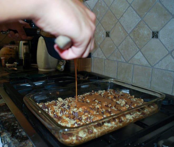 Making Caramel Oat Bars - Connor is drizzling the gooey caramel over the bars.