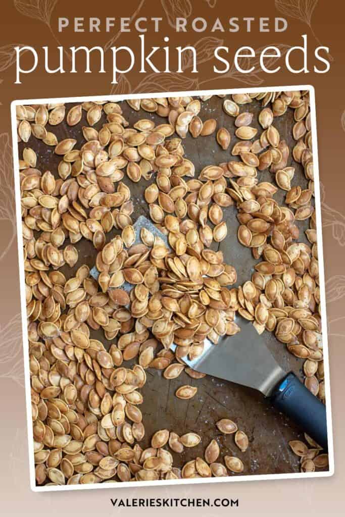 A spatula resting on a sheet pan full of roasted pumpkin seeds with text overlay.