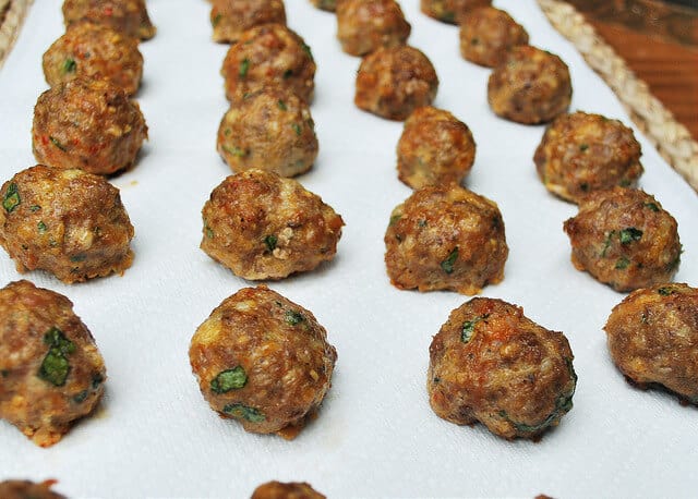 The baked meatballs are placed on paper towels to drain.