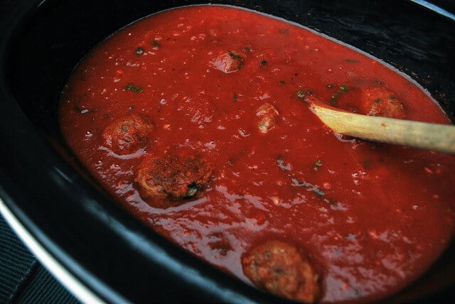 The meatballs are added to the basic red sauce in the slow cooker.