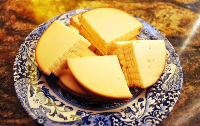 The sliced gouda cheese on a small blue plate.