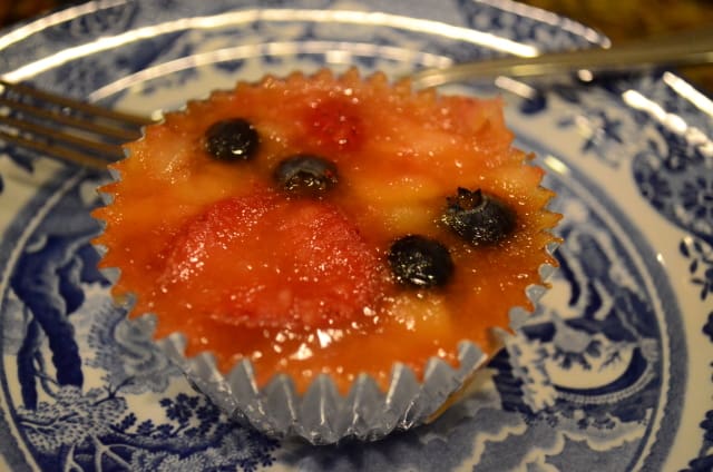 A Frozen Fruit Salad in a foil cupcake liner on a blue plate.
