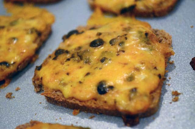 A close up image of a cheesy bread appetizer on a baking sheet.