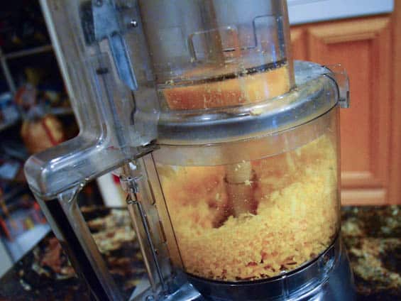 Cheese is grated in a food processor.