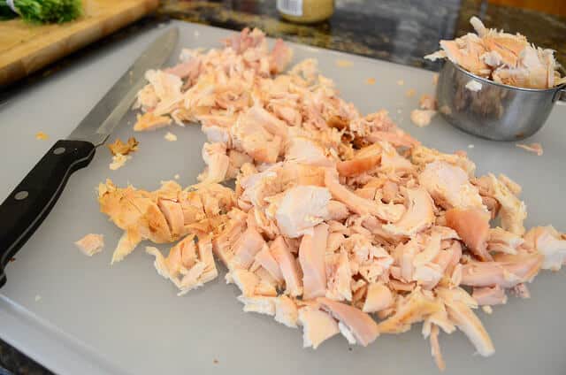 Chopped up rotisserie chicken on a cutting board.