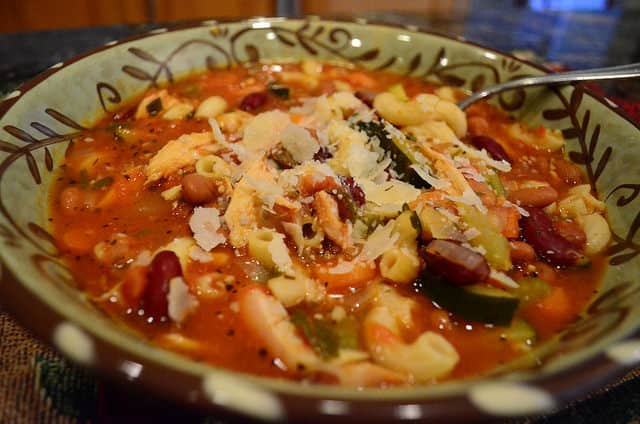 A bowl of Bonnie's Minestrone soup, garnished with Parmesan cheese.