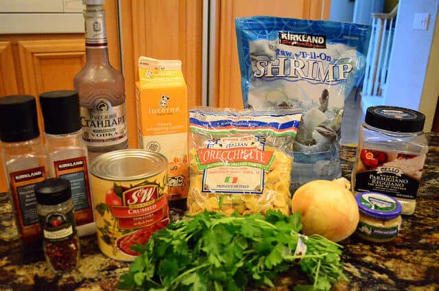 All the ingredients required for Orecchiette with shrimp in a vodka sauce, arranged on a counter top.
