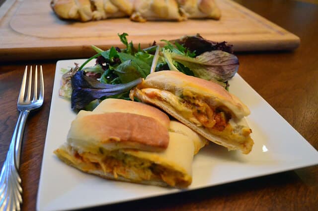 A calzone on a plate with a side of salad.