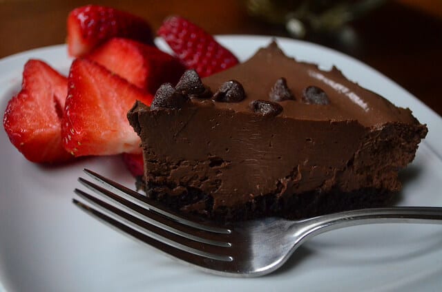A slice of chocolate pudding tart with strawberries.
