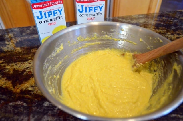 The cornbread being mixed together in a large mixing bowl.