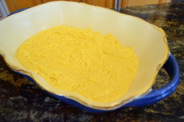 The cornbread layer is spread on to the bottom of a baking dish.