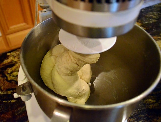 The bread dough has become one solid lump and is wrapped around the bread mixer hook.