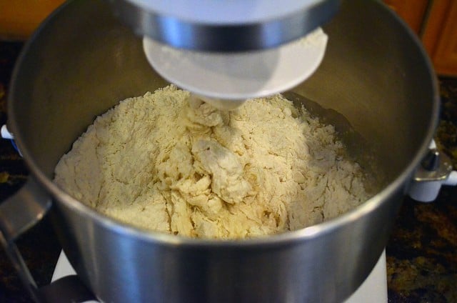 A view inside the bread mixer bowl with the ingredients being mixed together.
