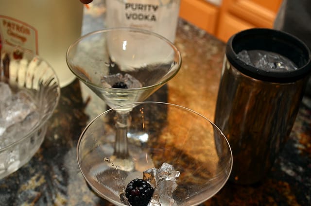 A berry is added on top of the ice in the martini glass.