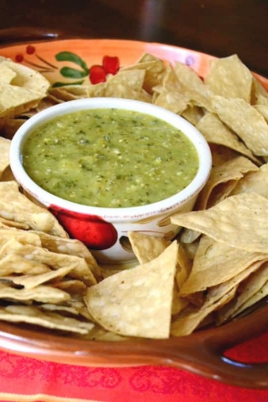 A serving dish with tortilla chips and salsa.