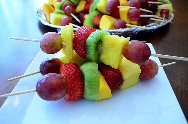 Three Fresh Fruit Kabobs on a serving plate.