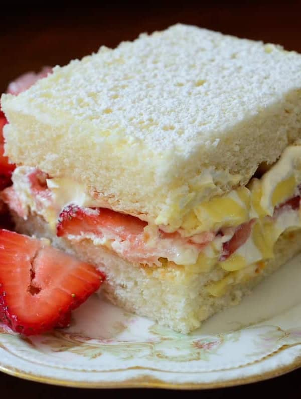 A slice of cake with a side of strawberries.