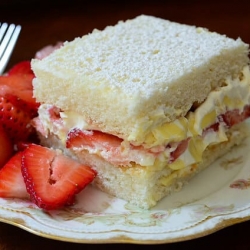 A slice of cake with a side of strawberries.