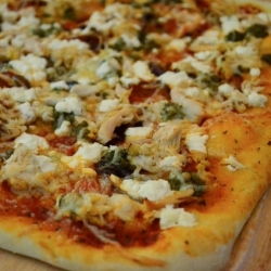A close up of chicken pesto pizza.
