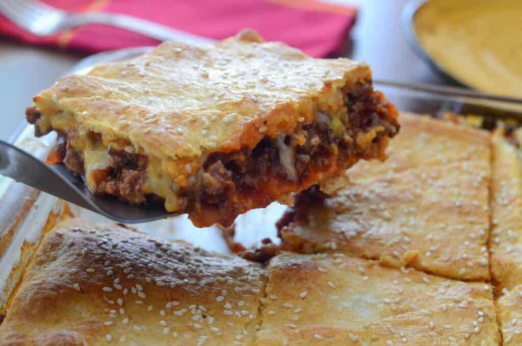 A slice of Sloppy Joe squares being lifted with a spatula.
