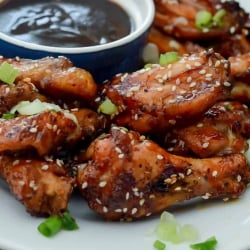 A plate of chicken wings with a dipping sauce.