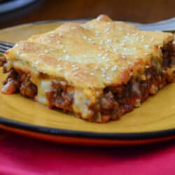 A sloppy joe square on a yellow plate.