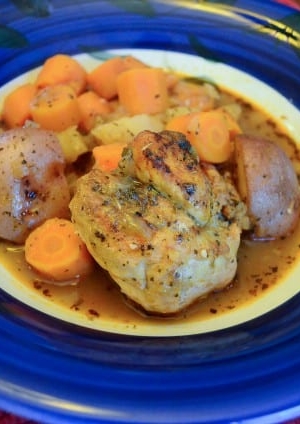A plate of chicken with potatoes and carrots.