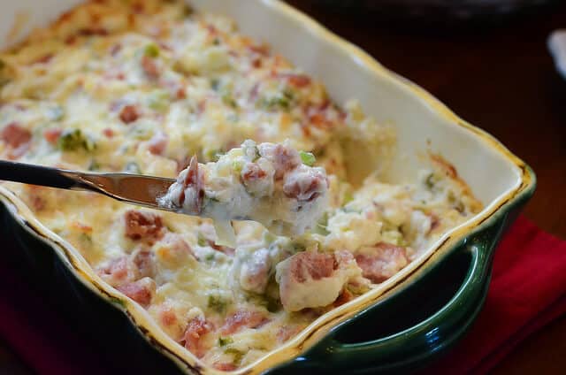 A knife lifts some kielbasa dip from a serving dish.