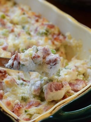 A knife lifts some kielbasa dip from a serving dish.