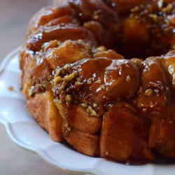 A close up monkey bread on a cake plate.