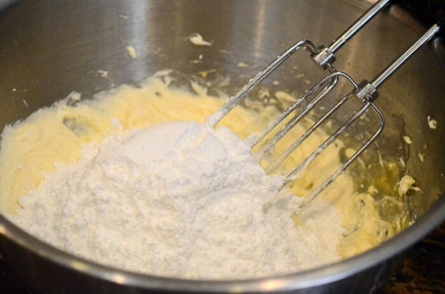 Powdered sugar is added to a mixture of cream cheese and lemon curd.