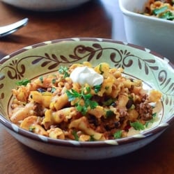 A bowl of taco pasta topped with sour cream.