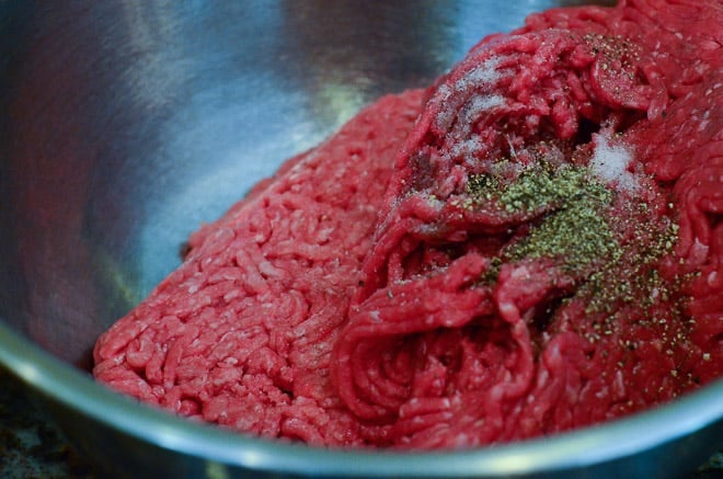 Ground beef and seasonings in a mixing bowl.