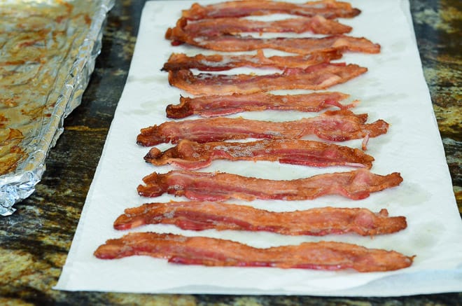 Cooked bacon draining on paper towels.