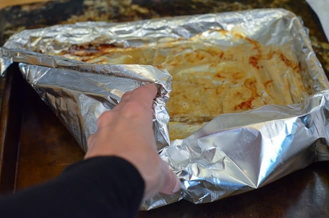 Gathering up the foil full of bacon grease from the baking sheet to throw away.