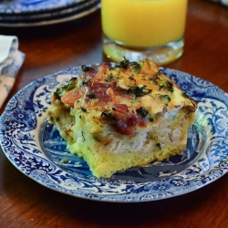 A slice of an egg breakfast bake on a blue plate,