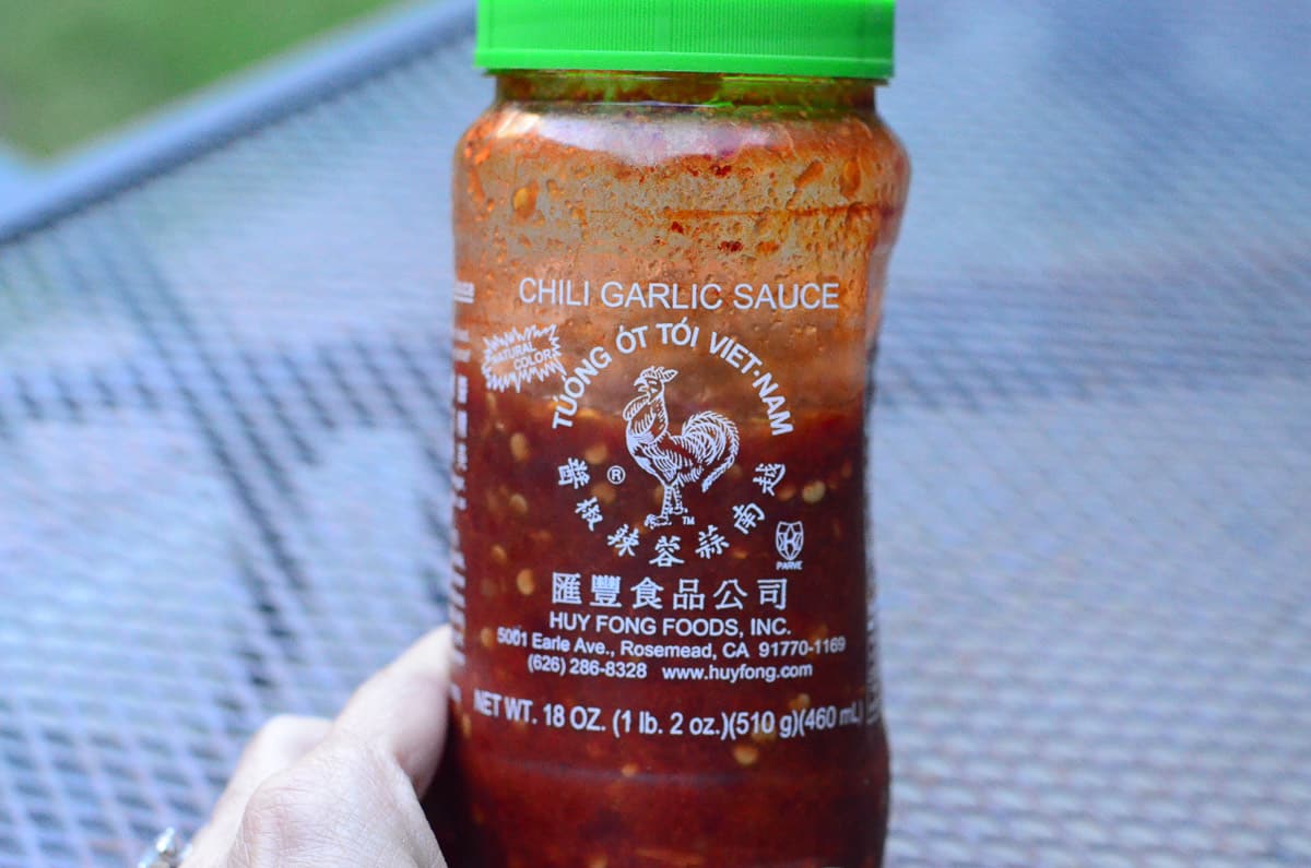 A plastic container of Chili Garlic Sauce.