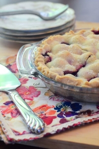 A cherry pie on a colorful cloth.