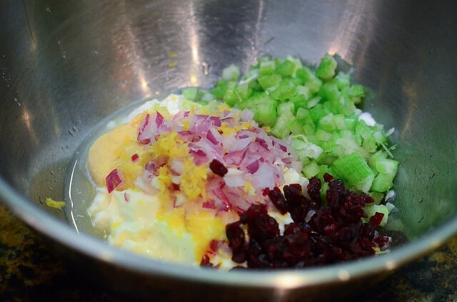 An in process image showing the ingredients for the dressing in a metal bowl.