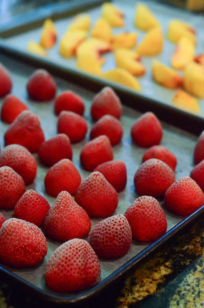A close up of frozen strawberries on a baking sheet.