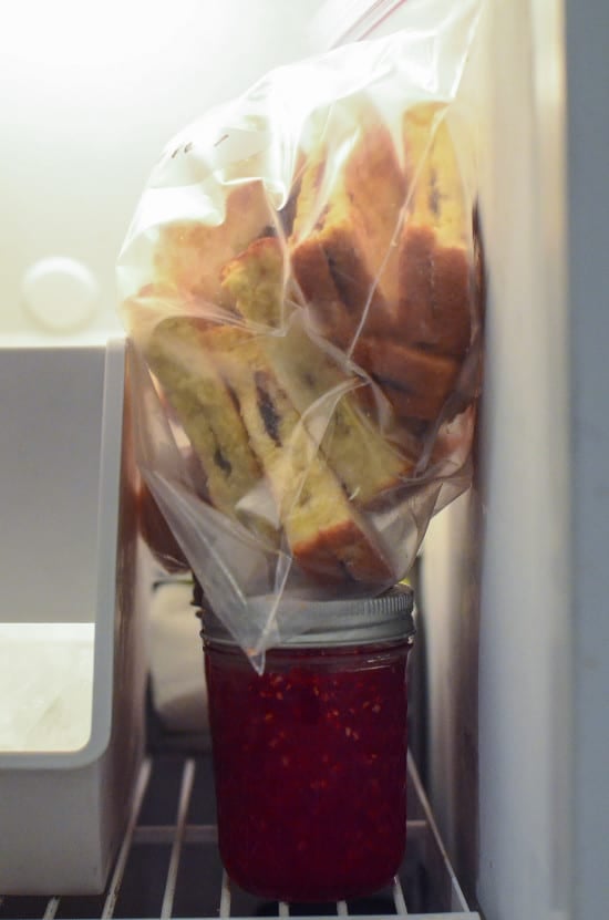 A bag of Nutella Stuffed French Toast Sticks sitting on top of jars of jam inside a freezer.