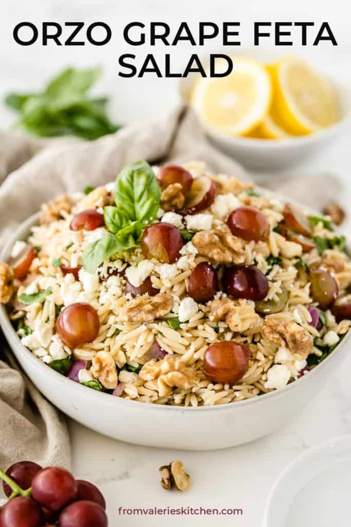 A white serving bowl filled with Orzo Grape Feta Salad with text overlay.