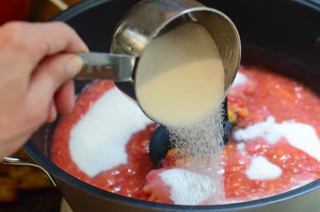 Sugar is poured into the jam maker.