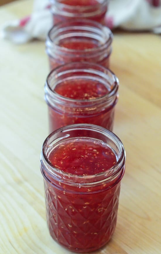 Several mason jars full of Peach Raspberry Freezer Jam.