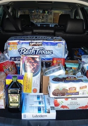 A car full of groceries with the trunk open.