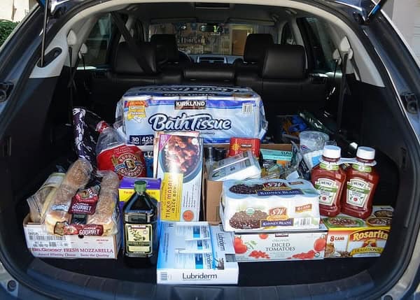A car full of groceries with the trunk open.