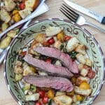 Panzanella Salad with strips of medium rare steak on top.